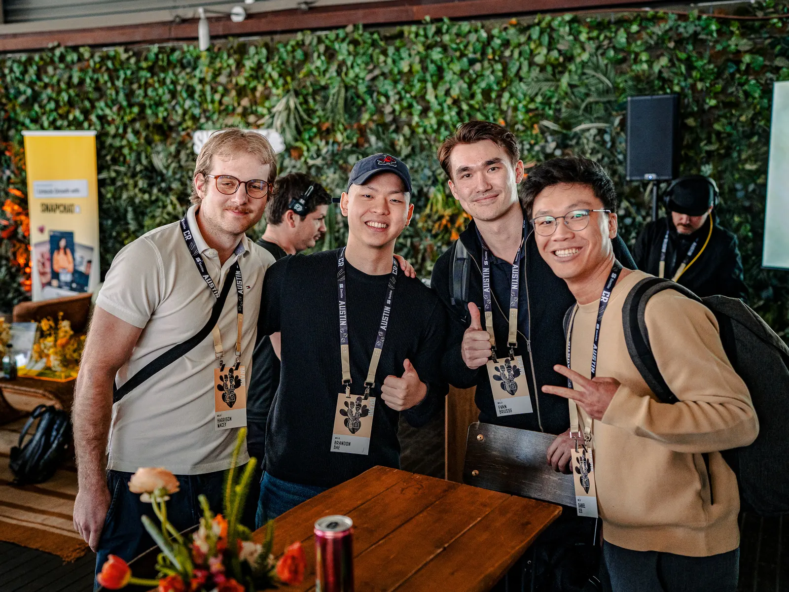A smiling group posing with thumbs up