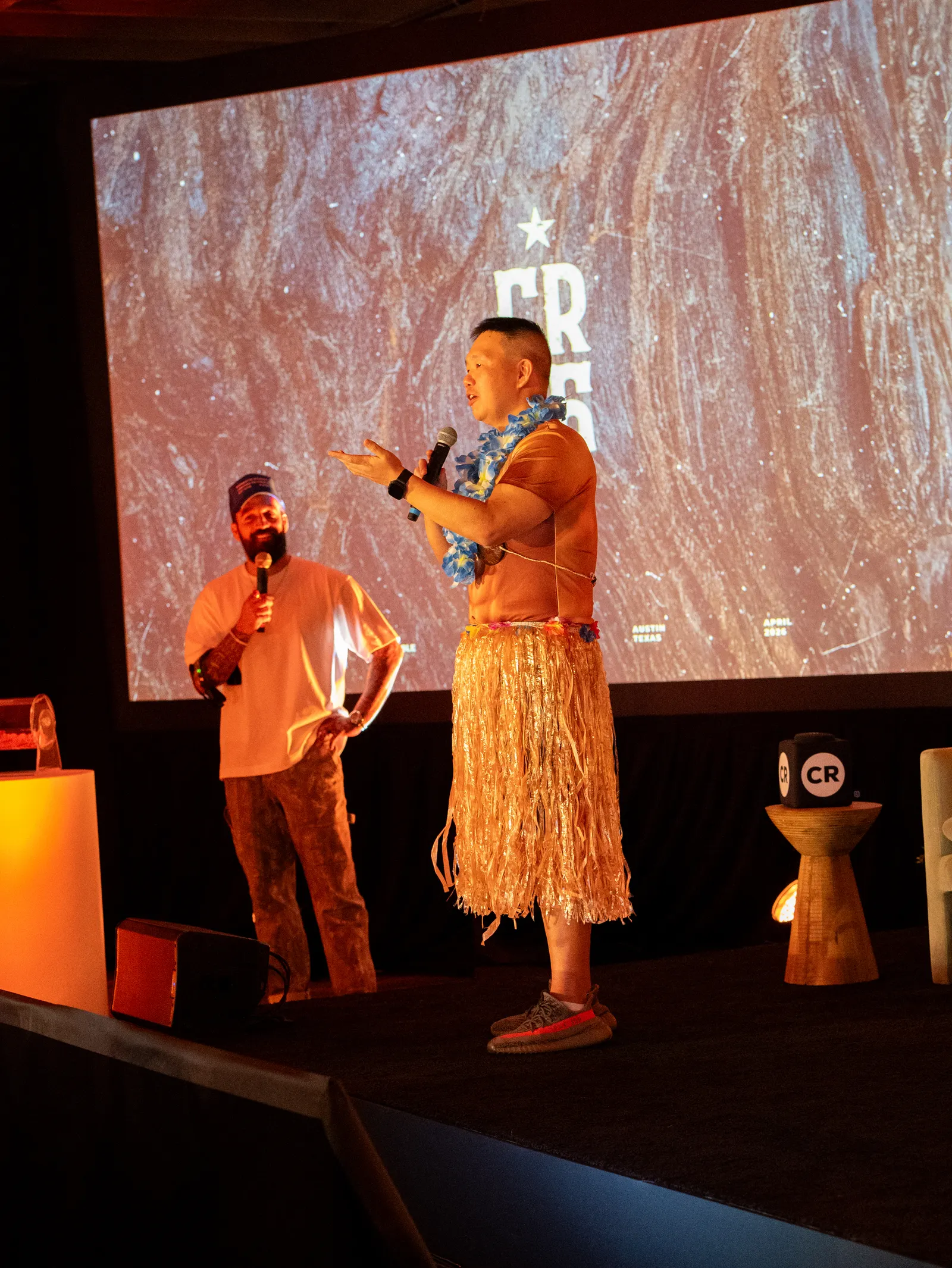 The host on stage with a hula performer