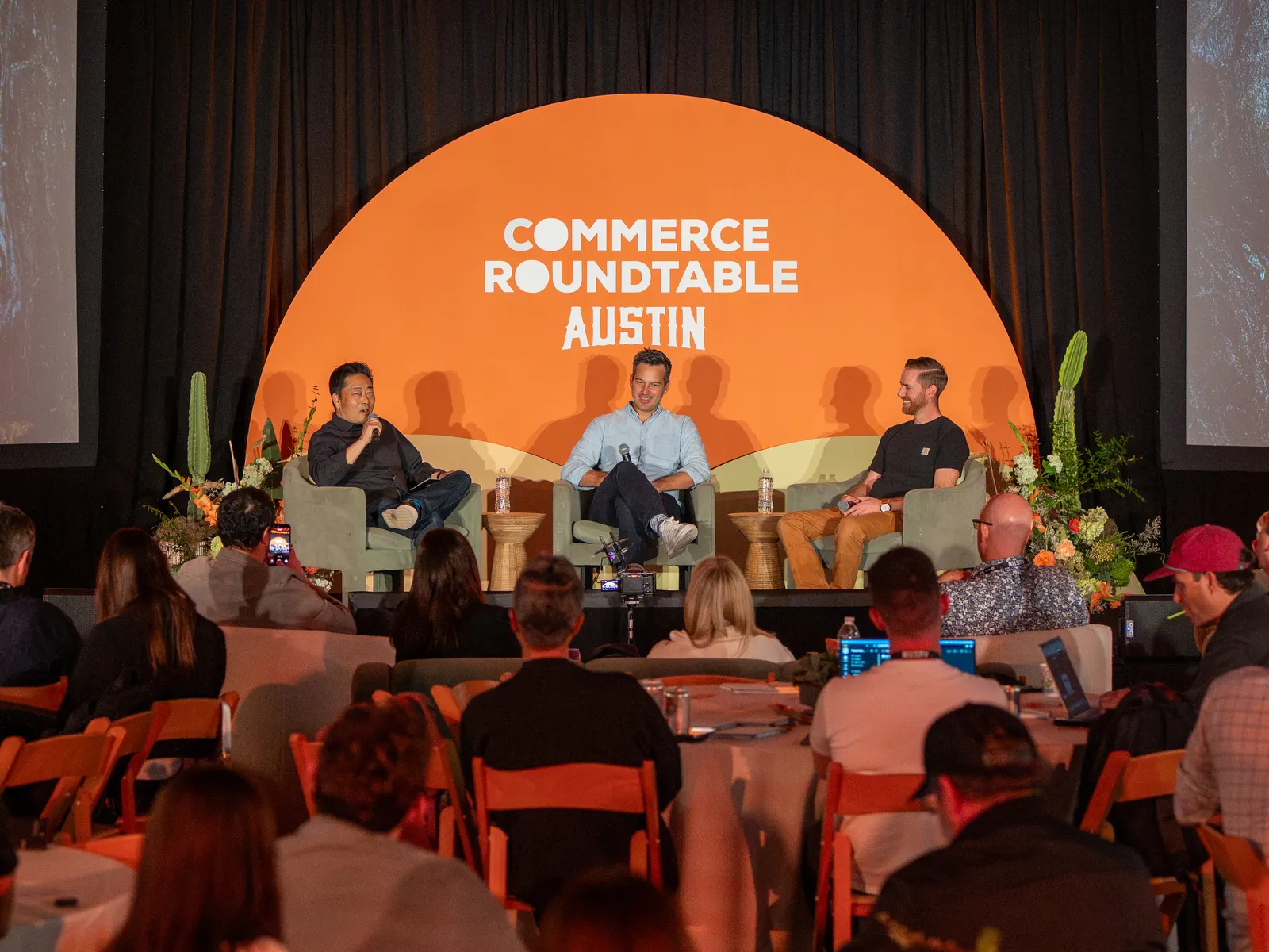 A panel on stage in front of a full audience