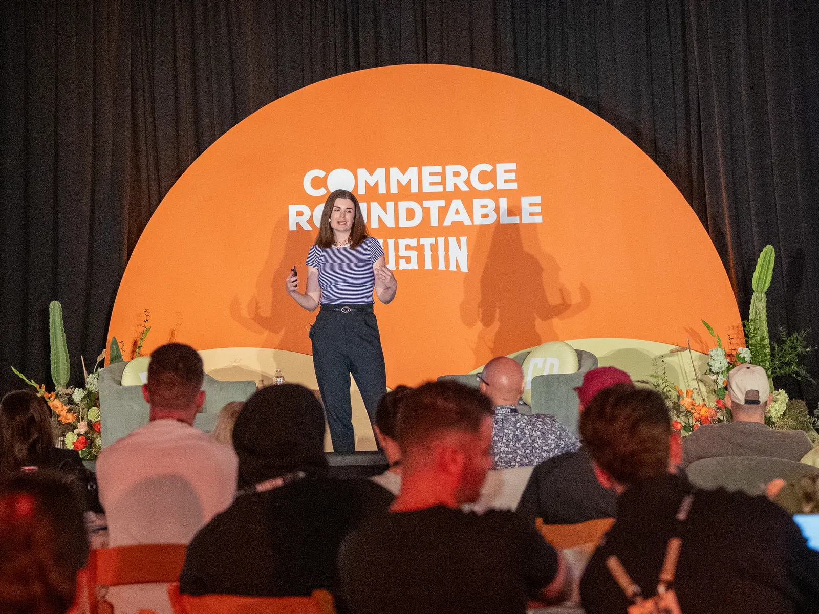 A speaker on stage with a full seated audience