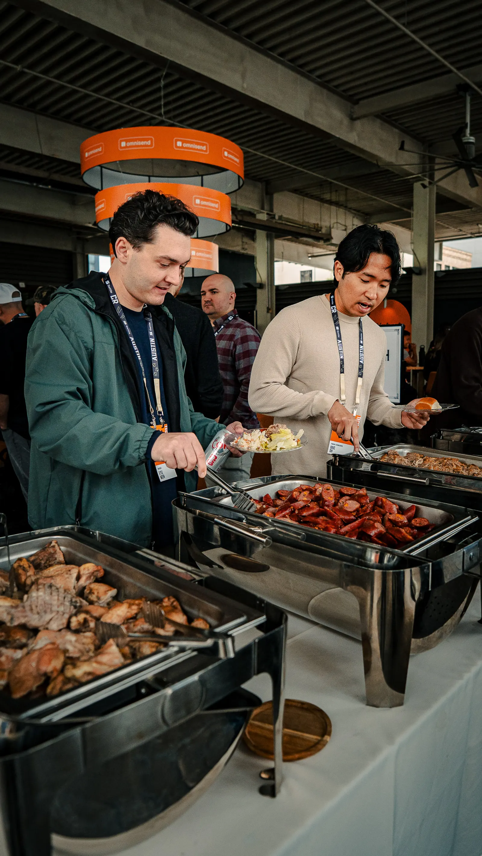 Attendees smiling while serving barbecue at lunch