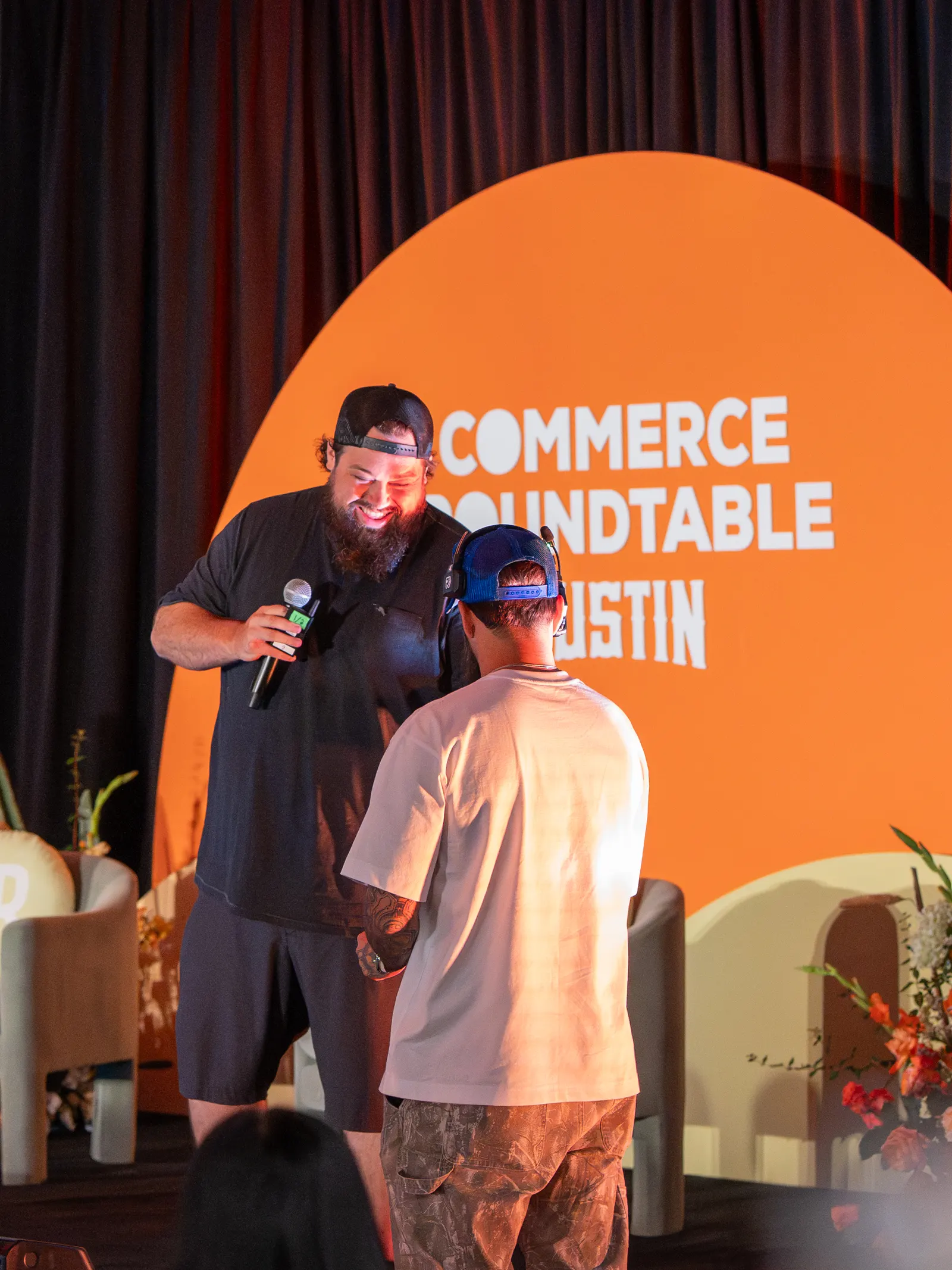 A speaker handing the mic to an attendee in the audience