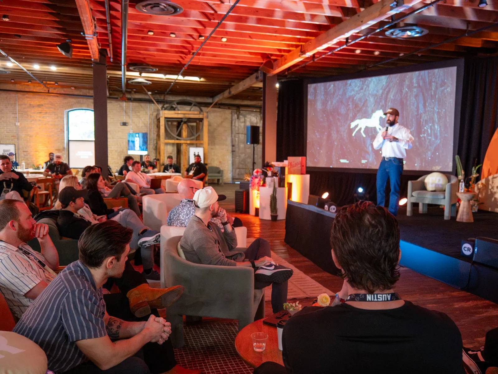 A full room watching a speaker on stage