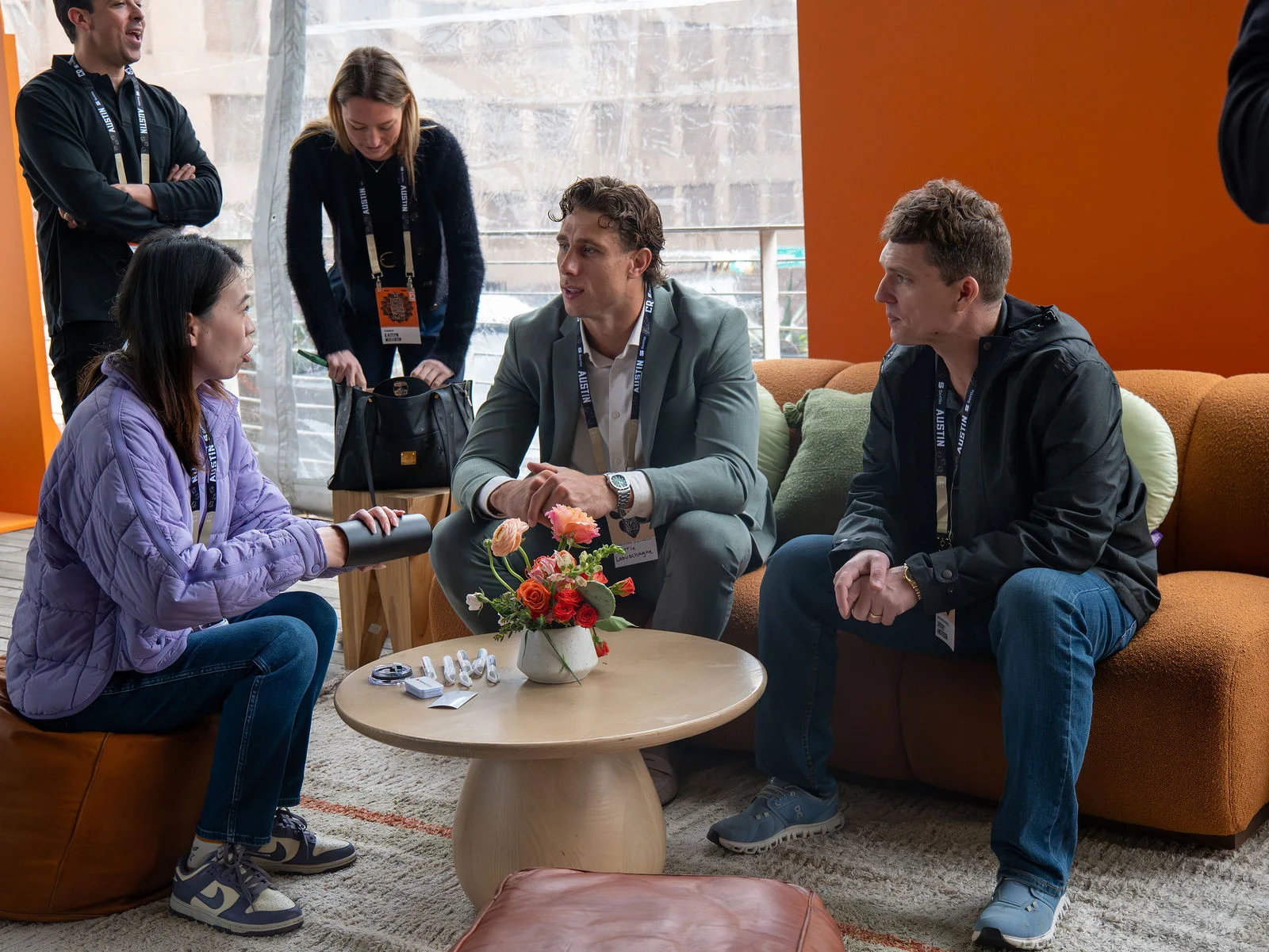 A group of attendees talking together around a low table in the lounge